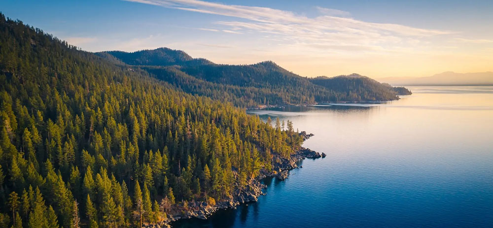 Aerial perspective of a tranquil lake bordered by towering mountains.